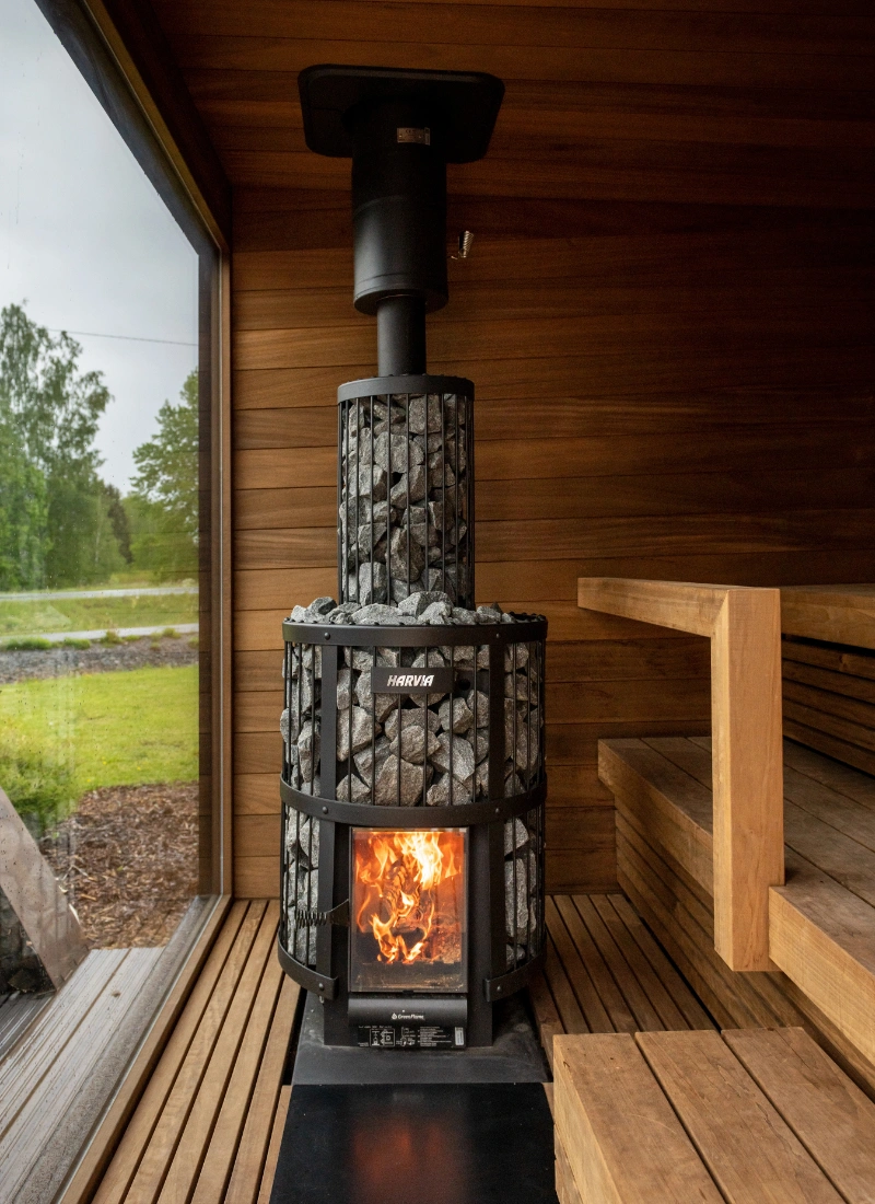Outdoor lakeside sauna building heated with a wood burning stove