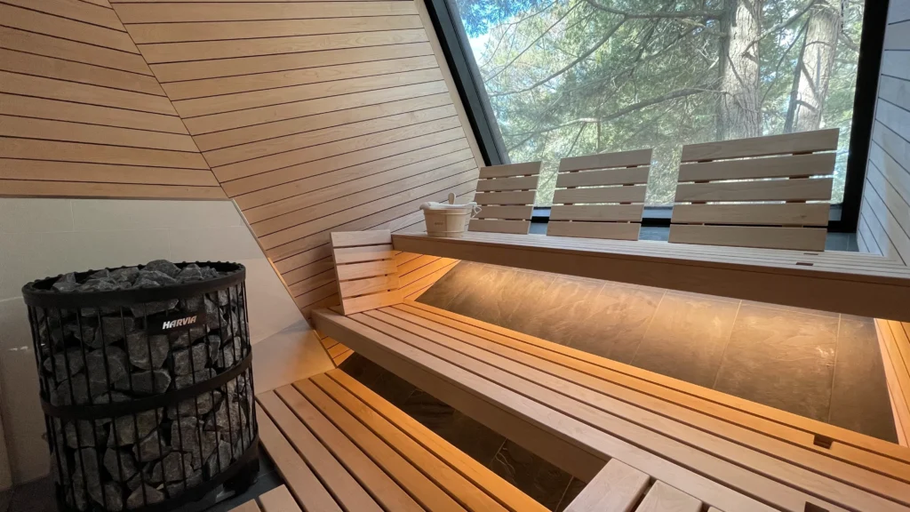 Sloped-ceiling custom sauna with window and Harvia heater