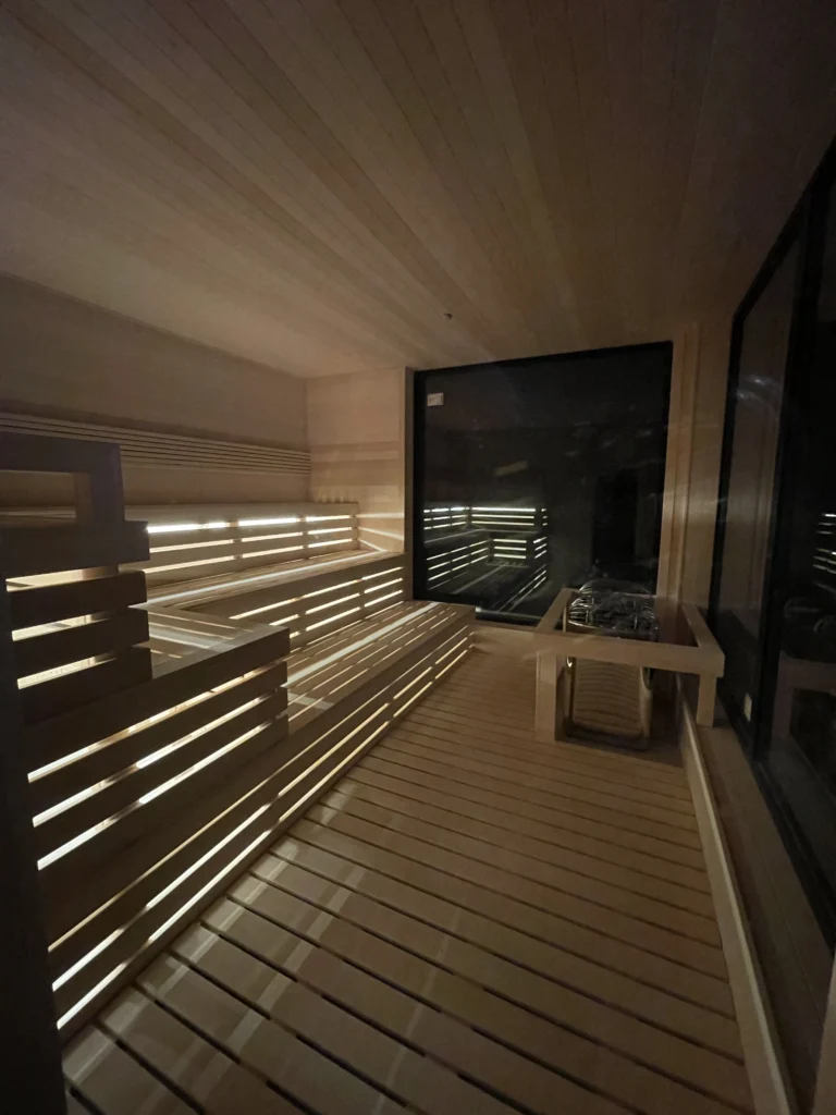 Long custom sauna with lit benches and black-framed window
