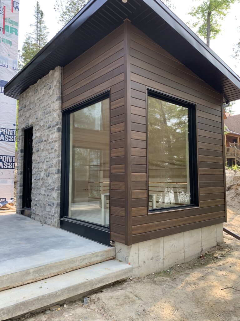 Modern custom outdoor sauna with stone and wood siding