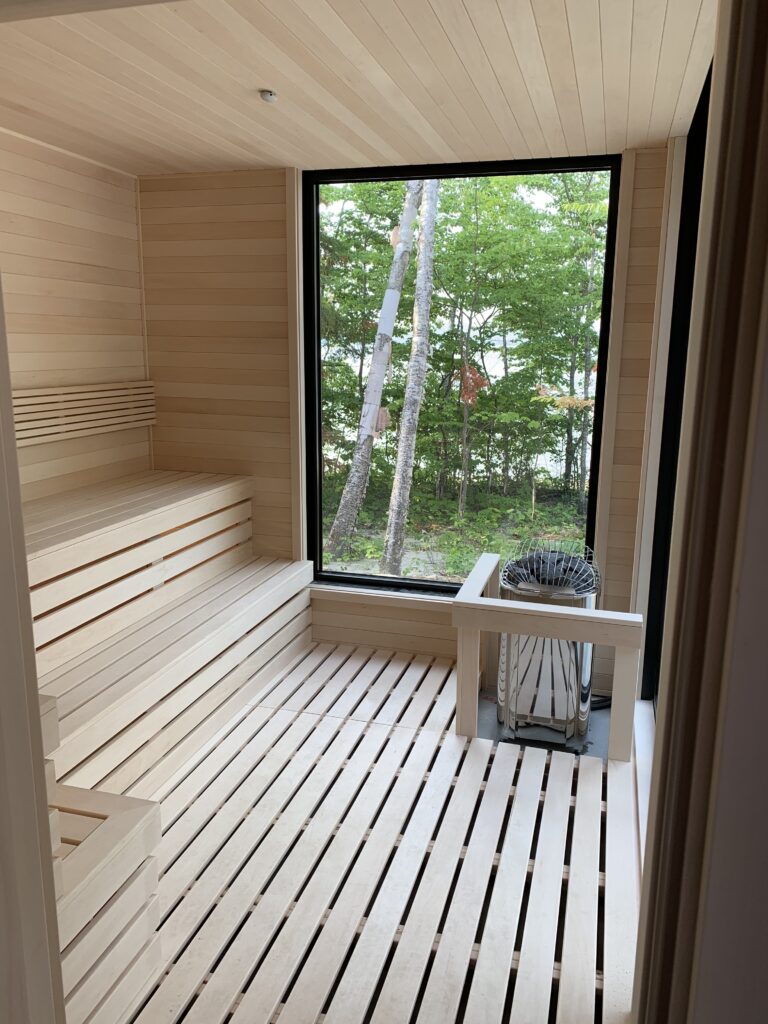 Modern outdoor sauna interior with a forest-view window
