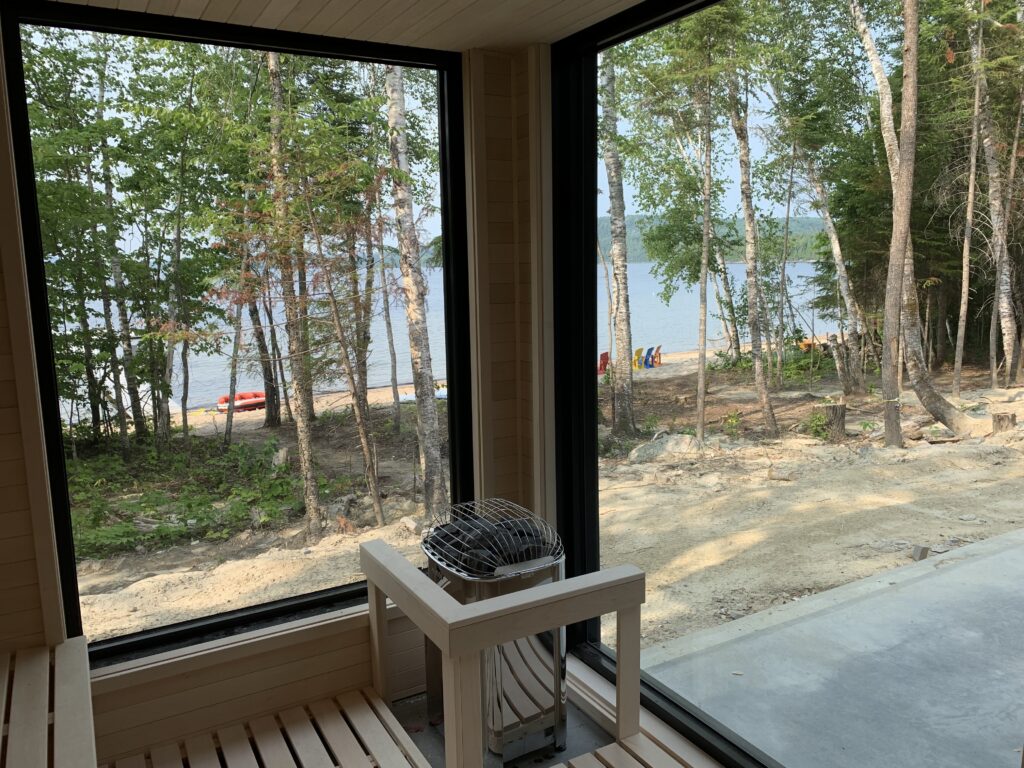 Outdoor sauna with corner windows overlooking a lake
